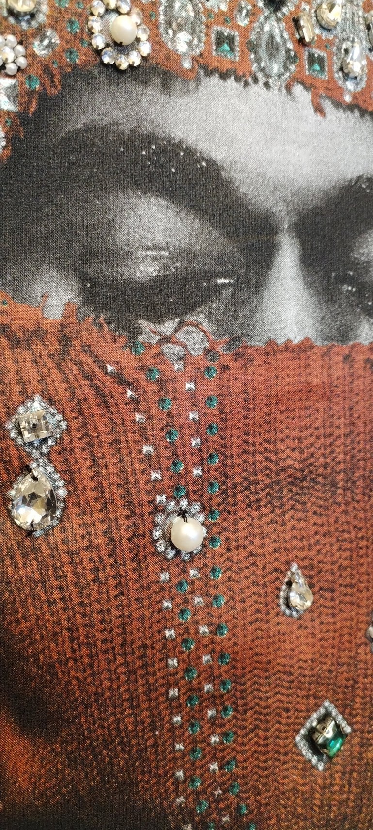 IH NOM UH NIT FW26 rust-brown cotton T-shirt with Mask Jewelry photographic print and applied crystals, decorative stones and pearl-like embellishments, front view.
